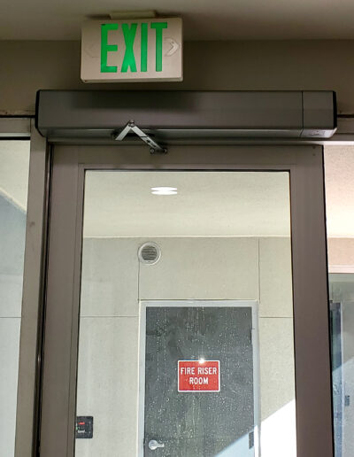 A single automatic door with an auto-operator seen above the glass.